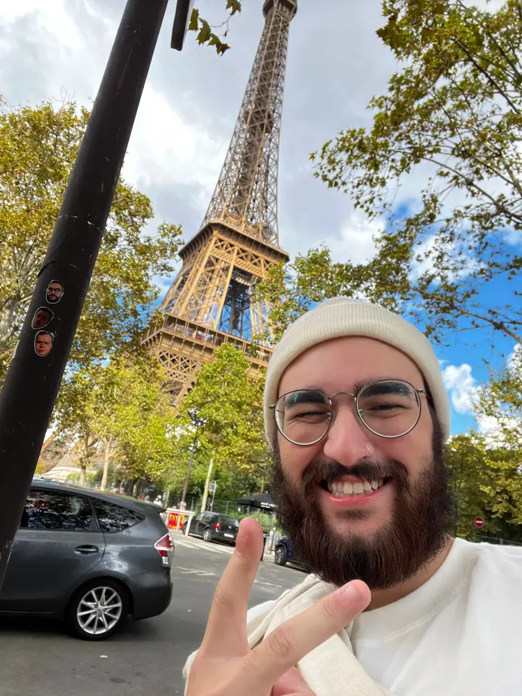 Retrato de Evaldo com a Torre Eiffel ao fundo, durante o dia.